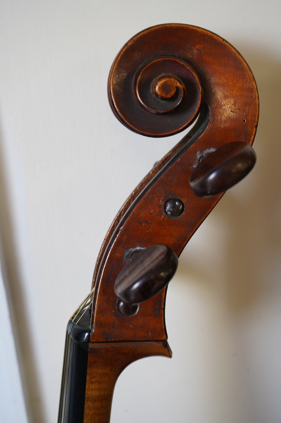 An early 19th century cello with a Stradivarius label, body 76cm, with a P&H bow, in a good modern case. Condition - poor